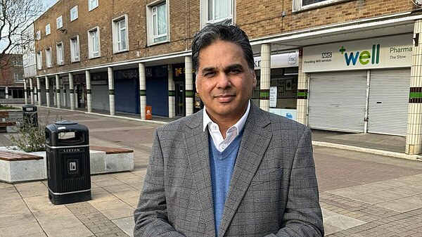 Riad Mannan wearing a jacket and open-necked shirt outside a shopping precinct in Harlow